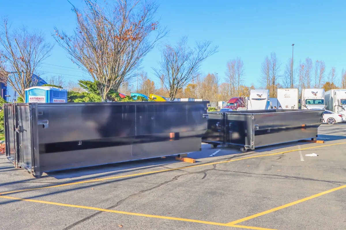 Professional dumpster rental service with roll-off container on residential driveway in Boston